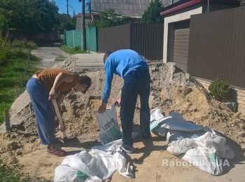 Погрузка песка в мешки для дальнейшей переноски